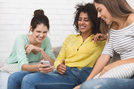 女人在智能手机上向朋友展示有趣的内容图片