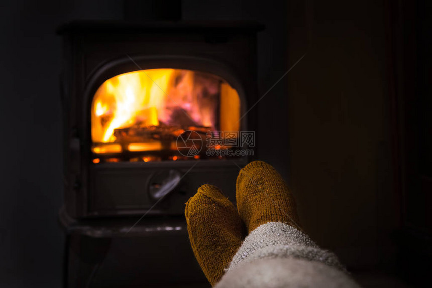 脚在圣诞壁炉旁穿着羊毛袜女人或男人穿着羊毛袜在温暖的火边放松脚的特写冬季和图片