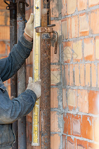 模板施工理念使用专尺子在未完工房屋中测量管高的成熟专家的裁图片