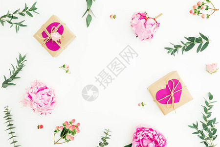 粉红玫瑰高压树枝和白背景的叶子和礼品的花状框架情人节构成平躺图片