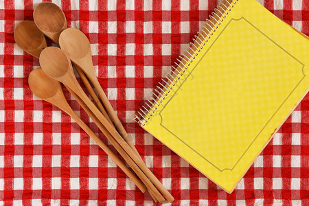 一张红色桌布上的木制混合勺子和烹饪手图片