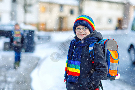 两个小男孩在降雪期间步行上学图片