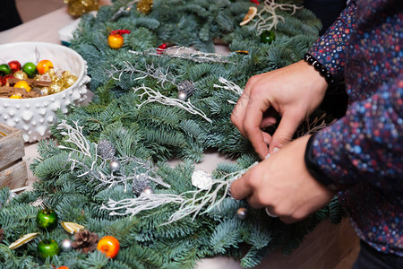 圣诞花环编织车间用云杉枝锥和各种有机装饰品在桌上装饰节图片
