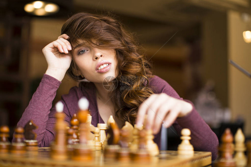 女人在室内下棋思考位置寻找胜利图片
