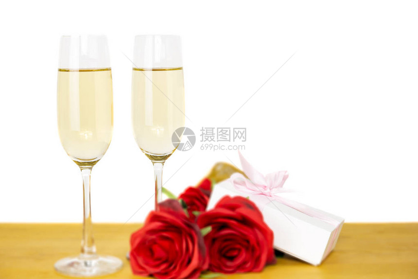 带玫瑰花和情人节礼物盒的香槟玻璃杯白图片