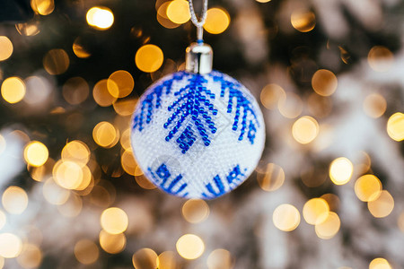 在fir树枝上的蓝白圣诞节球关闭金黄浅图片