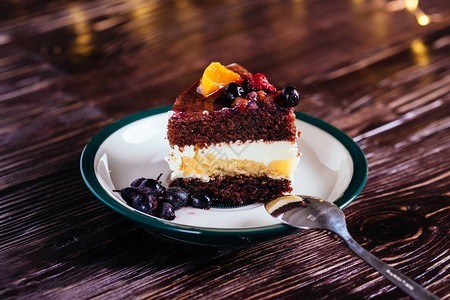 一块蛋糕夹着奶油巧克力水果甜点勺图片