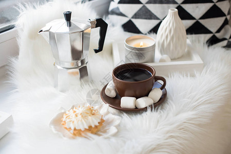 用枕头和毛毯在窗台上咖啡和糖果上安排舒适图片