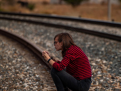 一个孤独的少女坐在铁轨上图片