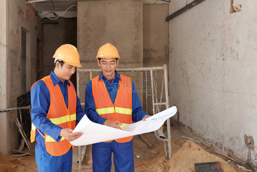 承包商和建筑工人在现场讨论蓝图图片