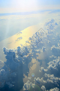 在云层之上飞行从飞机窗口的美妙的全景与白云飞过白云下面的白云与天图片