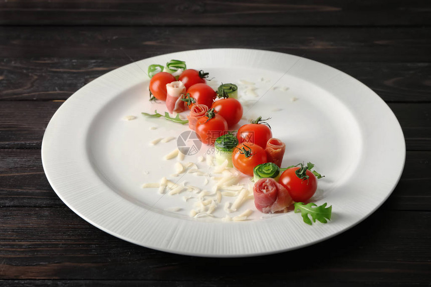 深色木质背景中带西红柿和奶酪的盘子图片