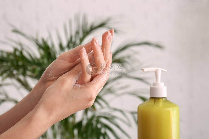 在家用液体肥皂洗手的女人图片