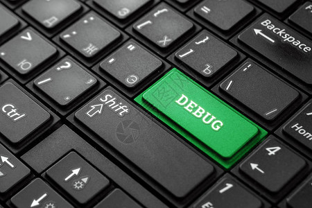 黑色键盘上带有调试字样的特写绿色按钮图片