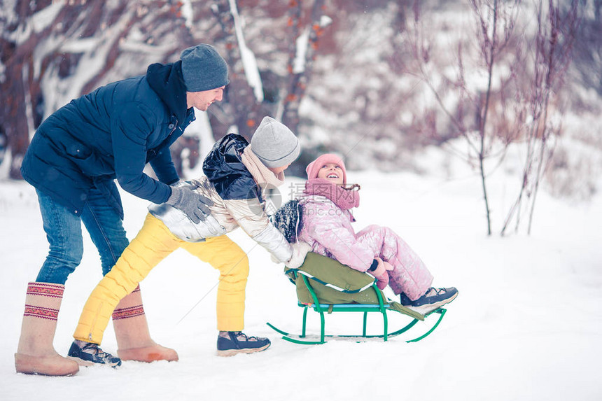 小孩子们喜欢乘坐雪橇家庭雪橇孩子们在雪地户外玩耍圣诞节前夕图片
