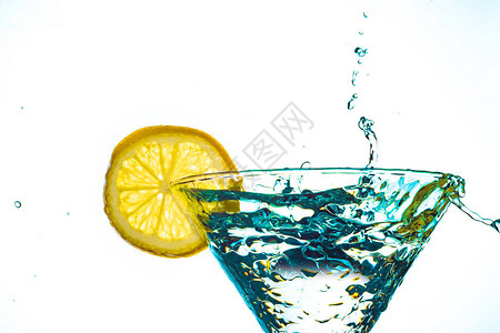 蓝色鸡尾酒在玻璃杯中喷洒柠檬以图片