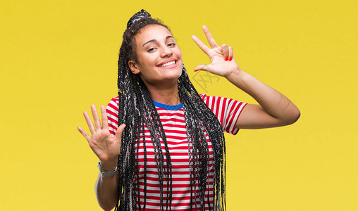 年轻的辫发非洲裔美国女孩在孤立的背景下展示并用八号手指向上方图片