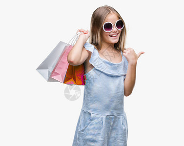 年轻美丽的女孩拿着购物袋在销售时被孤立的背景指向图片