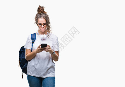穿着背包耳机和智能手机的褐发女学生图片