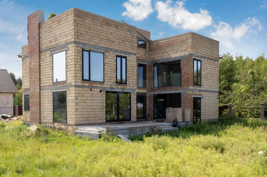 新的不完全的住宅建设房屋用砖和塑料窗遮图片