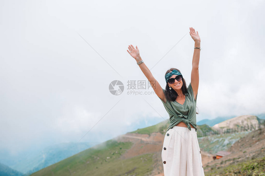 美丽快乐的年轻女子在山的雾背景图片