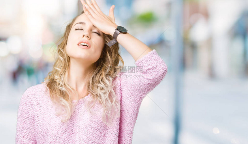 美丽的年轻金发女郎在与世隔绝的背景下惊讶地用手捂着头因为错误图片