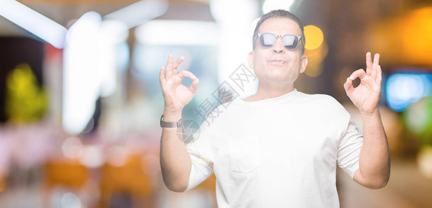 中年的阿拉伯男子穿着白色T恤和太阳镜图片