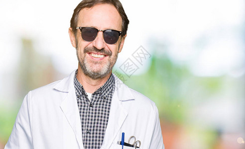 帅气的中年医生男人戴着墨镜面带快乐和凉爽的笑图片