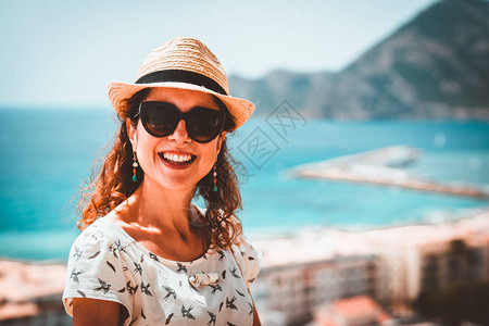 快乐的旅游女人戴着稻草太阳帽图片