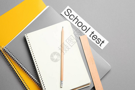 文具和纸与灰色背景上的文本学校测试图片