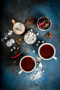 热巧克力杯巧克力碎片糖棉花糖红辣椒和香料深蓝色混凝土背图片