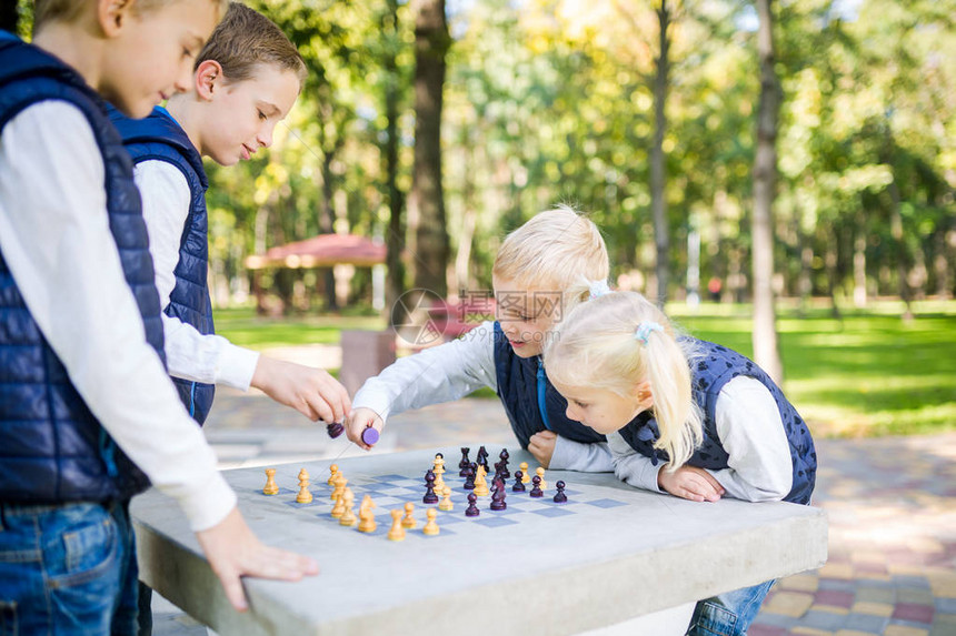 主题儿童学习逻辑发展思维和误算动作推进大家庭兄弟姐妹高加索男孩和女孩下棋公园阳光明图片