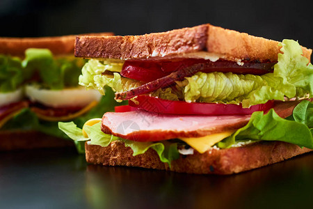 自己做的三明治有生菜和火腿黑背景图片