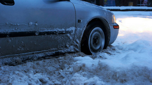 汽车在雪地里熄火了汽车轮被困在雪堆中的特写暴风雪过后图片