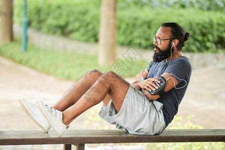 长着胡子的帅男子在户外做腹部扭伤手术时背景图片