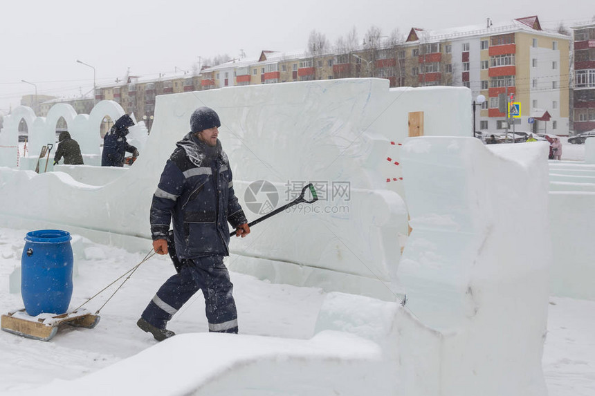 一个人在冰镇上带着雪橇一桶水图片