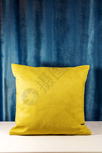 黄色枕头在白色天鹅绒材料覆盖的桌子上滚动图片