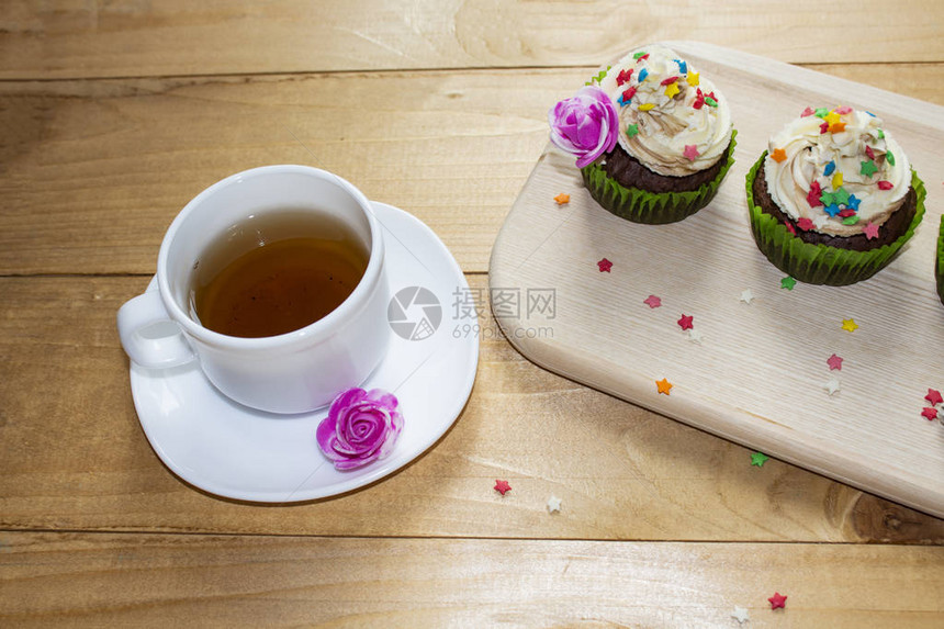 切木板上的松饼奶油装饰品茶叶图片