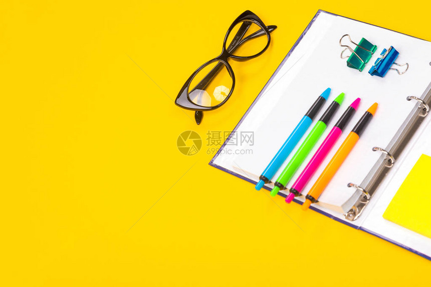 打开的日记本和眼镜旁边的四个明亮的把手被隔离在黄色的桌子上办公室工作人员工作区教学和儿童创造图片