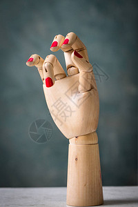 灰色背景中用木头制成的人体模型手图片