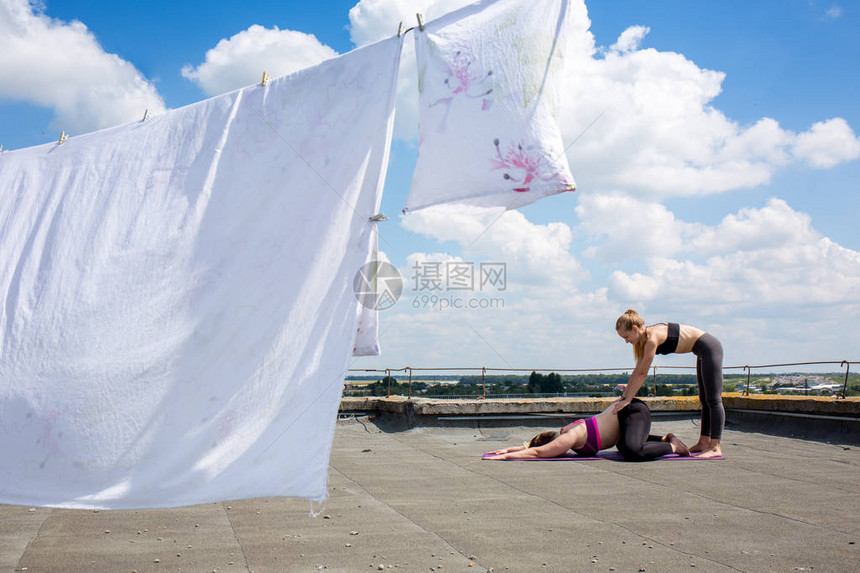 年轻妇女在房子的屋顶上训练图片