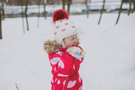 在寒冬衣着和帽子的有趣的小女孩图片