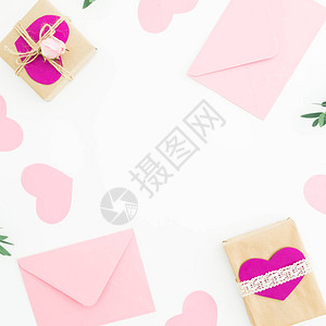 白背景的粉红面条玫瑰信封和礼物的情人节日框架平躺图片