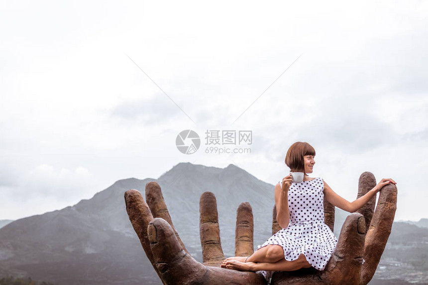 在山地背景上搭着热咖啡的女旅行者图片