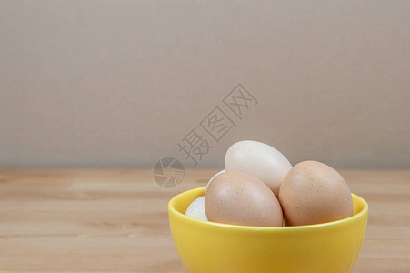 鸡蛋放在桌上的黄色碗里上图片
