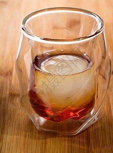 纯威士忌在双壁威士忌杯里喝冰球在木棍顶上打着图片