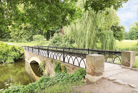 穿过公园池塘的古石桥图片