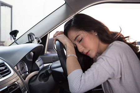 疲累的年轻妇女在车里睡觉高清图片