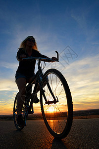 日落时骑着山地自行车的女人运动和活图片