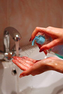 女孩在流水下用液体肥皂洗手图片